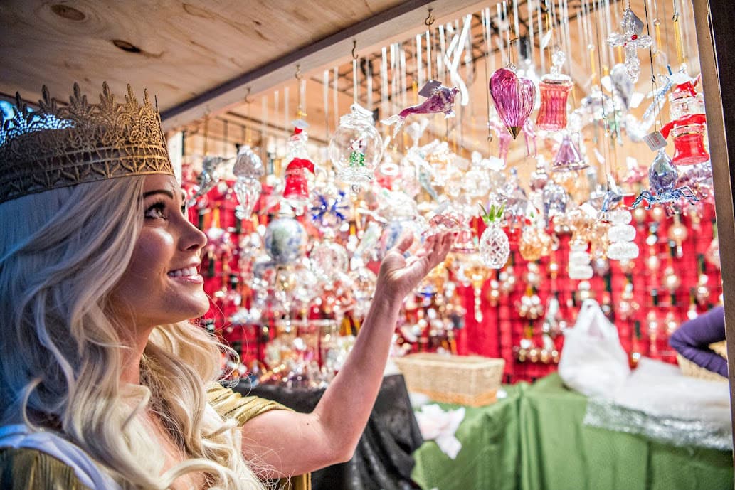 A woman admires glittering holiday ornaments at the Denver Christkindl Market
