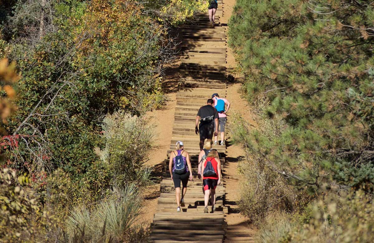 Several people are spaced out on the climb to the top of an old railroad trail