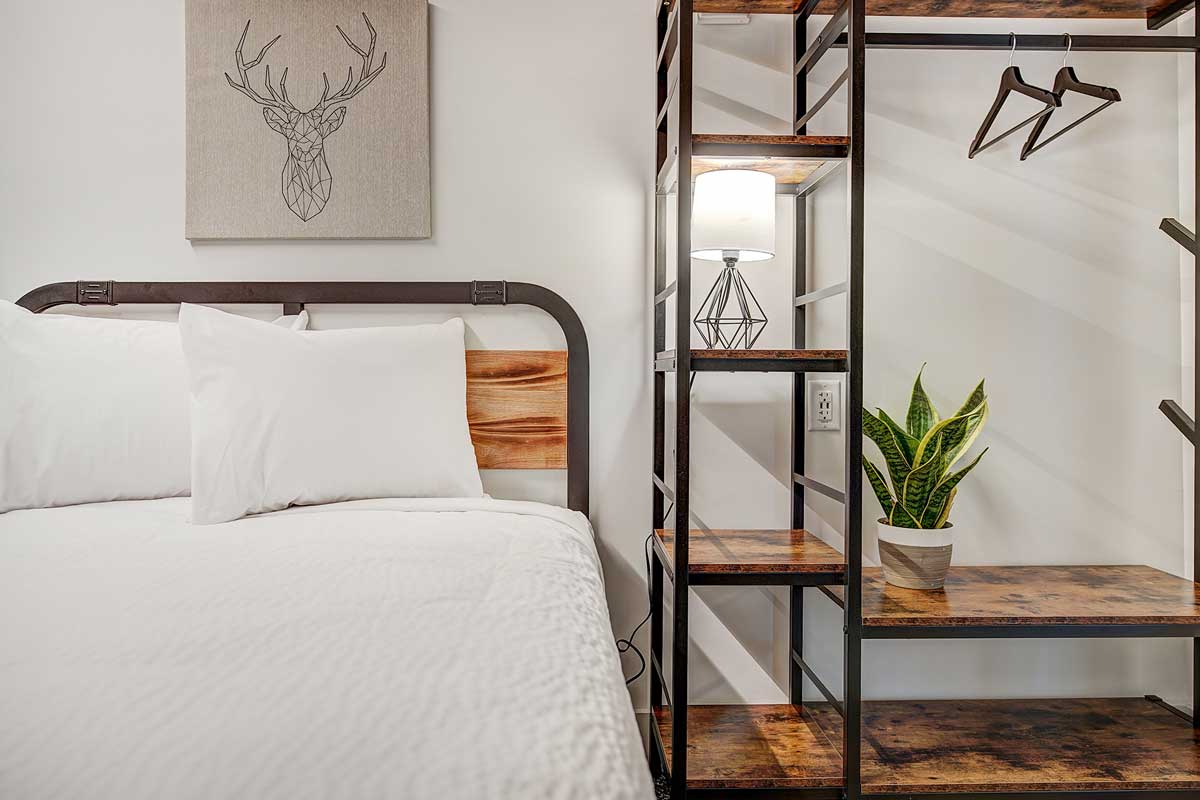 Private room at The Pad in Silverthorne outfitted with modern furniture and comfy white bedding