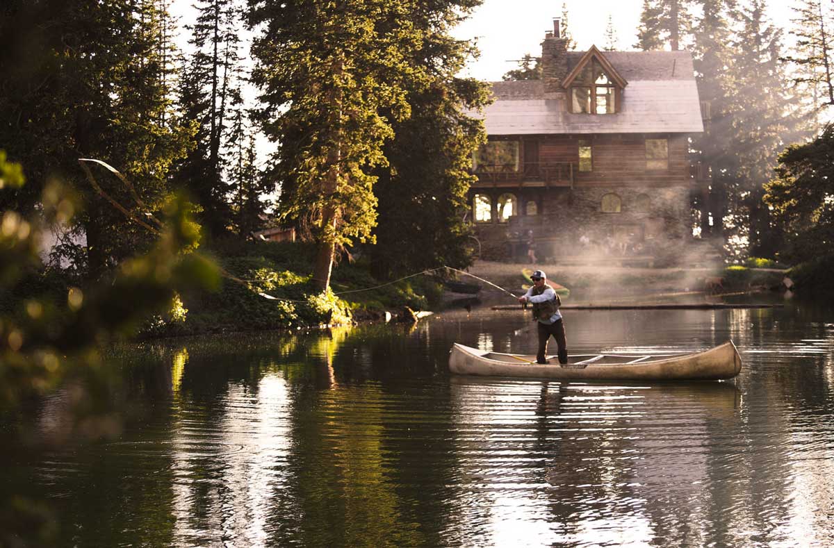 A man fishes on a canoe on Alta Lakes by The Observatory at Alta Lakes near Telluride