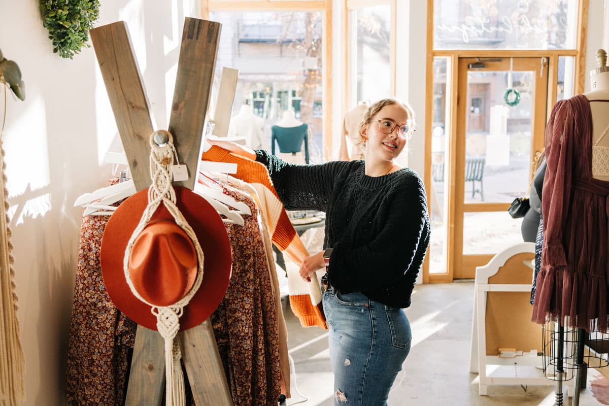 Woman browsing a clothing rack at Blush Boutique in Greeley, Colorado.