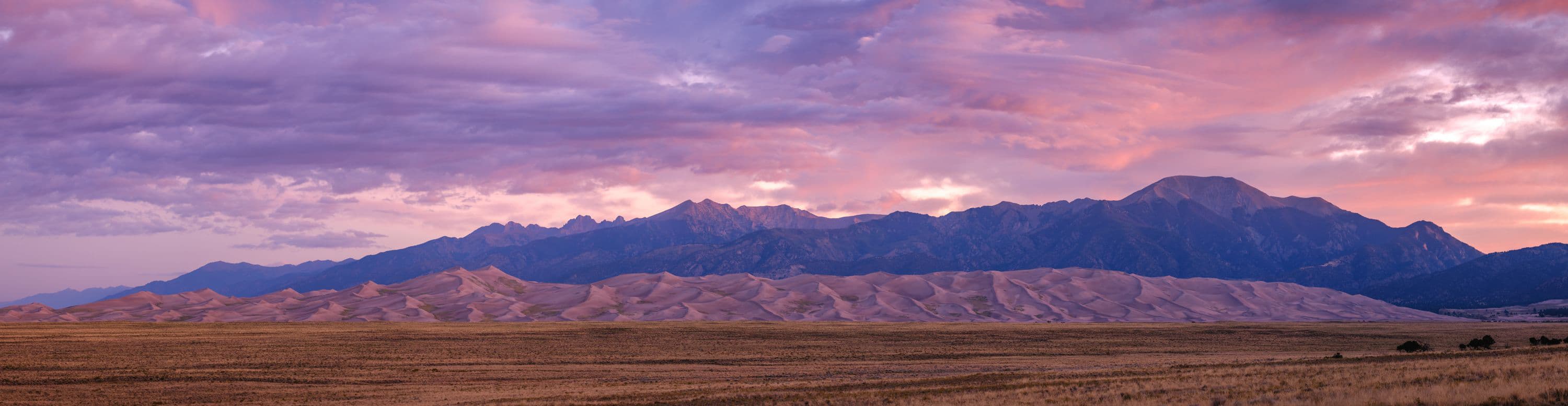 The sun rises over Great Sand Dunes National Park and Preserve and the Sangre de Cristo Mountains in Alamosa Colorado