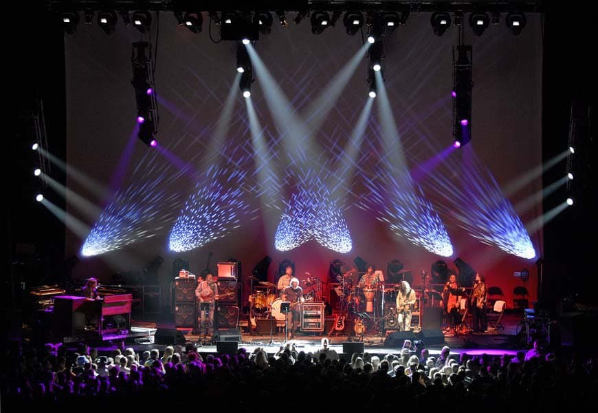 A nighttime concert with a band and strobe lights at 1stBANK Center.