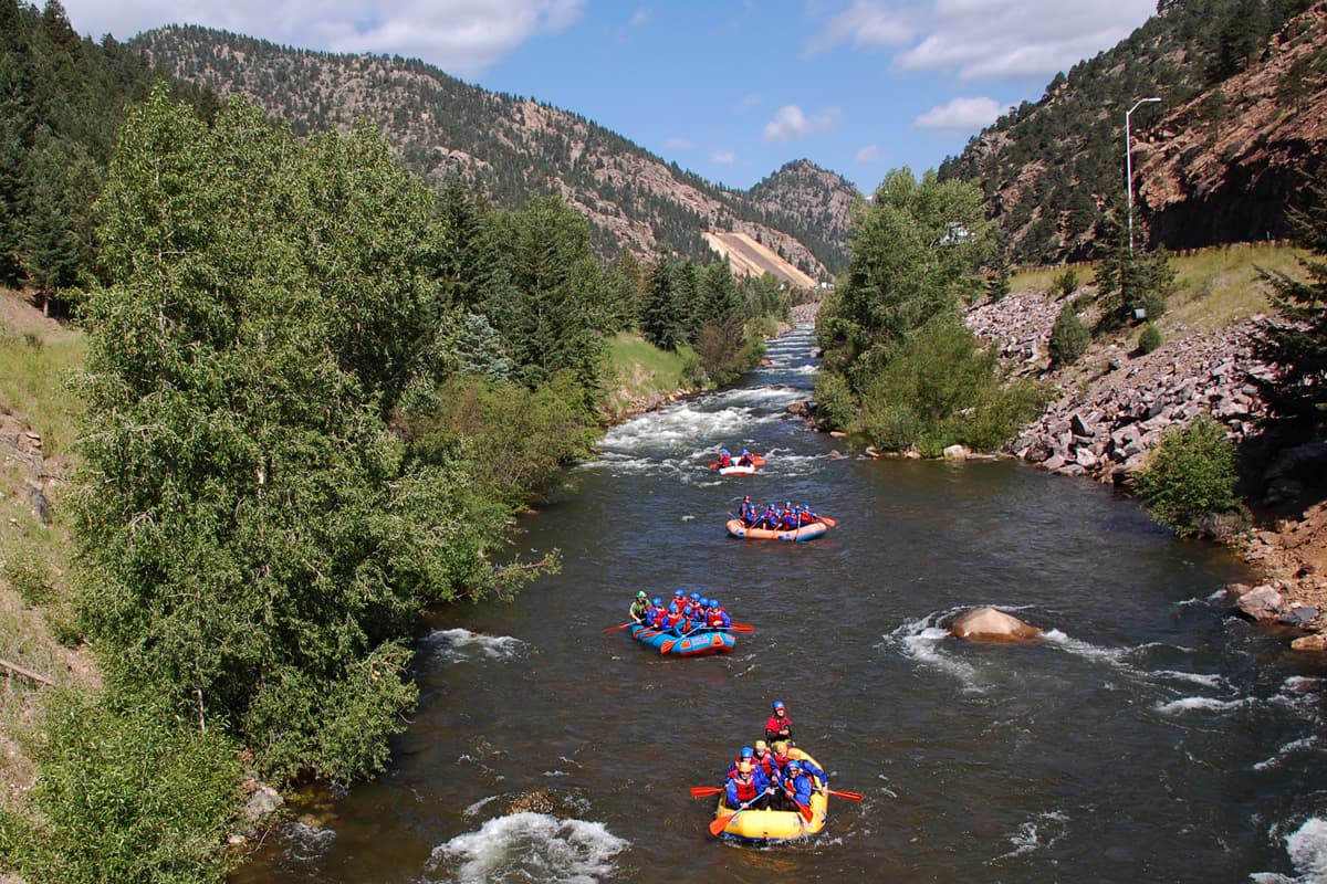 Rafts are scattered across calm waters on on Clear Creek