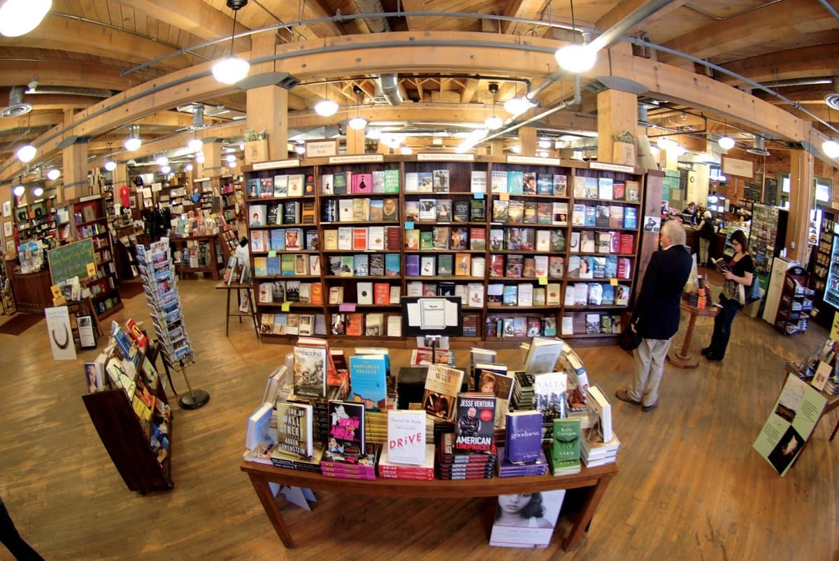 People browse shelves of books inside a quaint bookstore