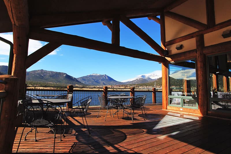 View of a blue lake a rolling blue hills from the outdoor dining section of lodge.