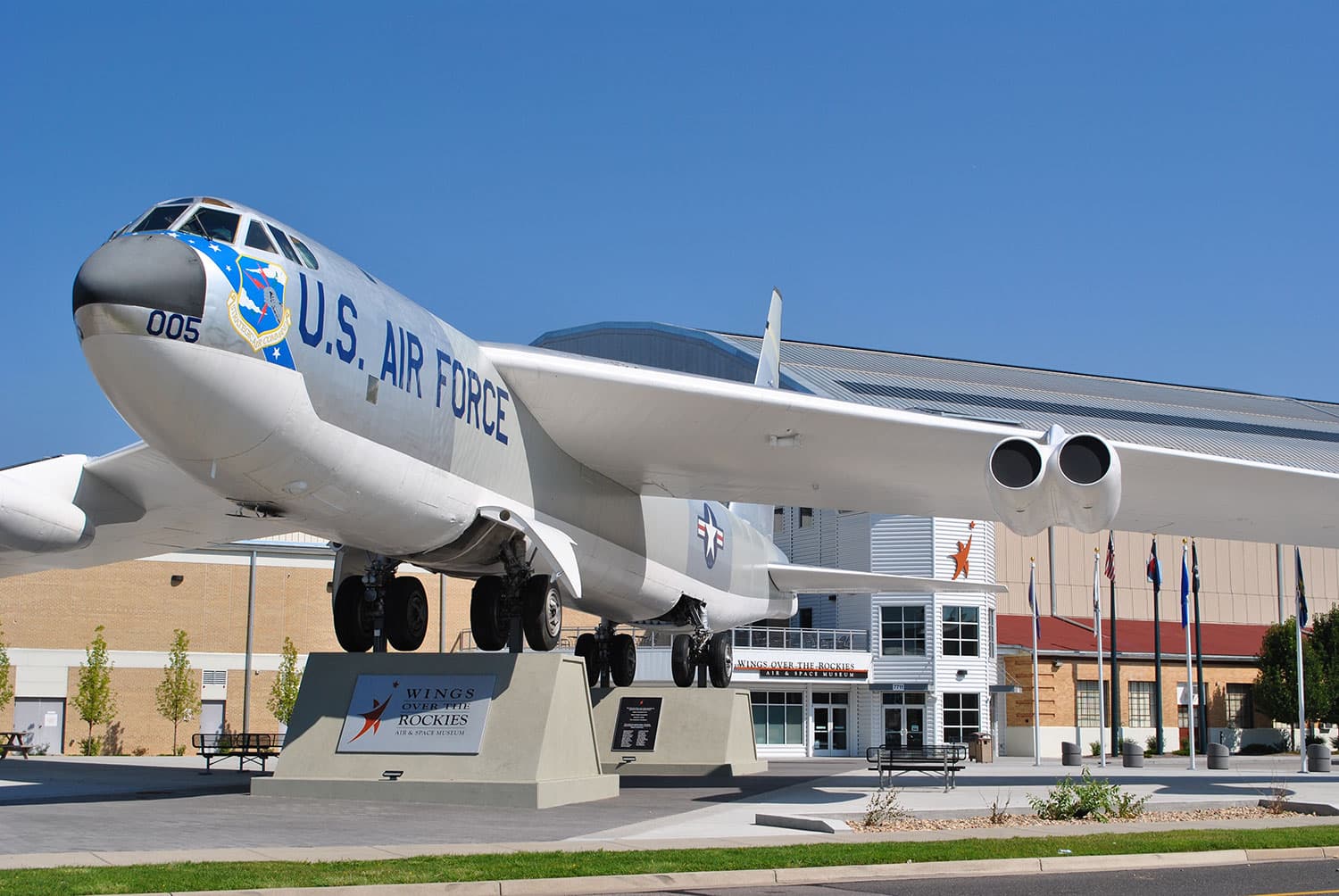 A large, blue and white, commercial plane is parked on a platform outside for travelers to admire at a museum in Denver, Colorado.