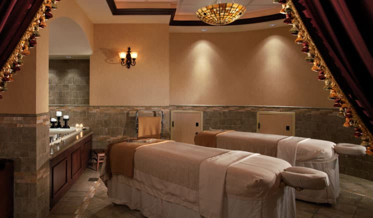 Two massage tables in a dimly lit room at The Brown Palace Hotel and Spa