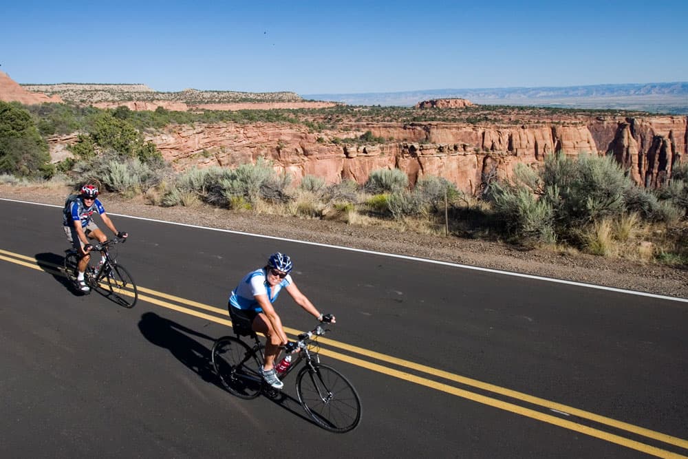 Two people road biking in Colorado National Monument, near Fruita, CO