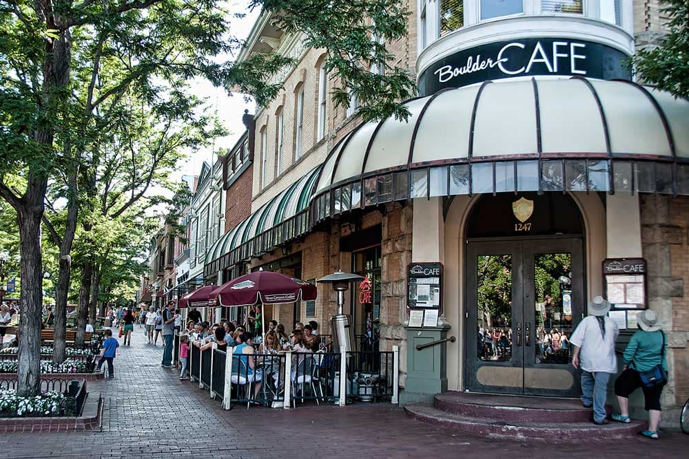 The Boulder Cafe, a corner building along the Pearl Street Mall, features a glass domed awning along its perimeter and fenced in outdoor dining.