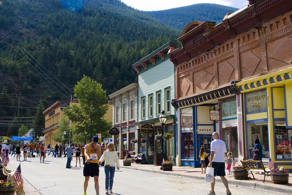 Colorful shops in Georgetown, CO on a sunny day with mountains in the background