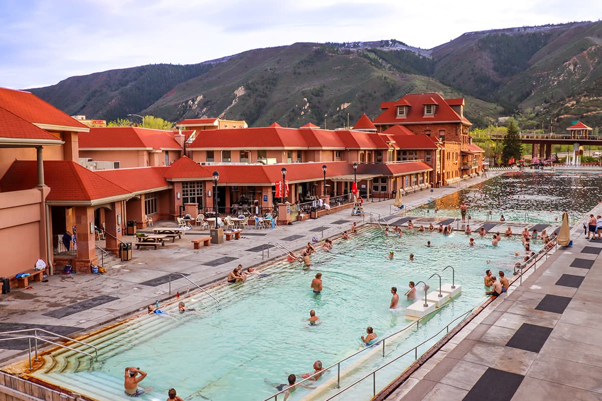 People soak and unwind in the steaming waters of the Glenwood Hot Springs Resort's Therapy Pool.
