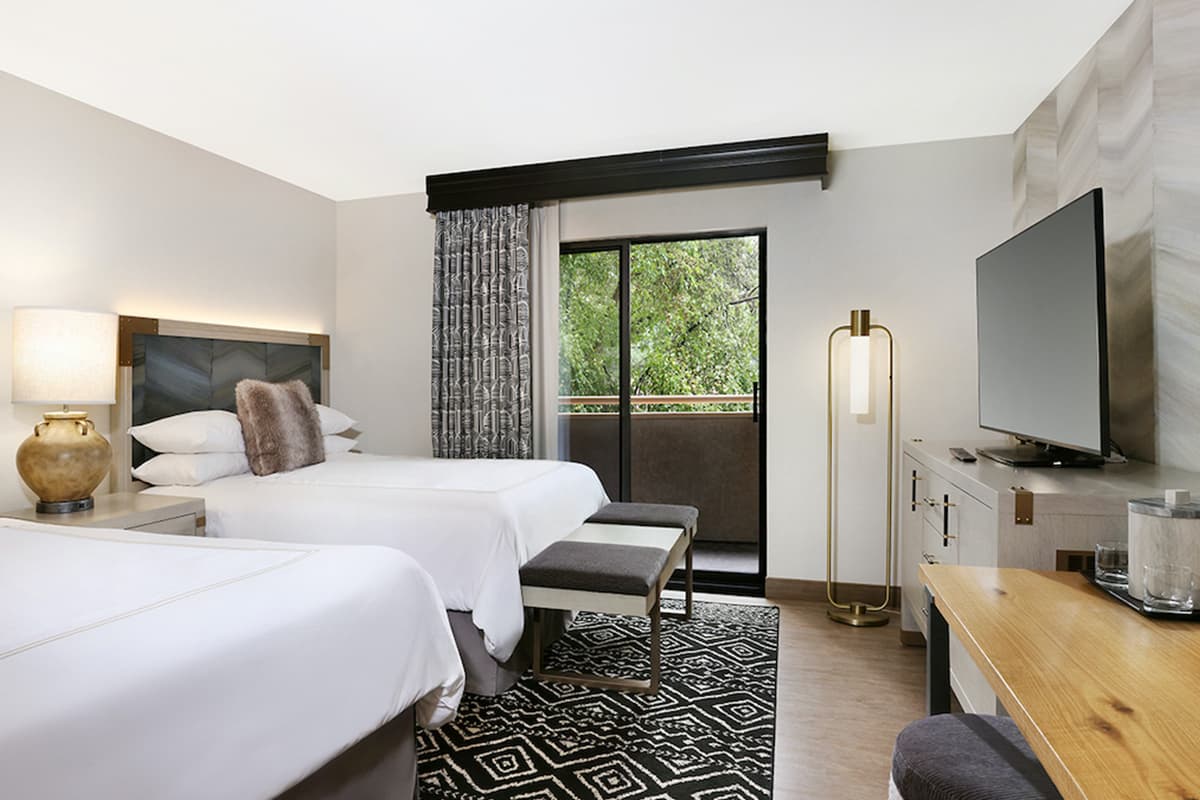 A chic, yet simple room at Glenwood Hot Spring Resort's Lodge offer balcony views and a soft beds for guests to sleep.