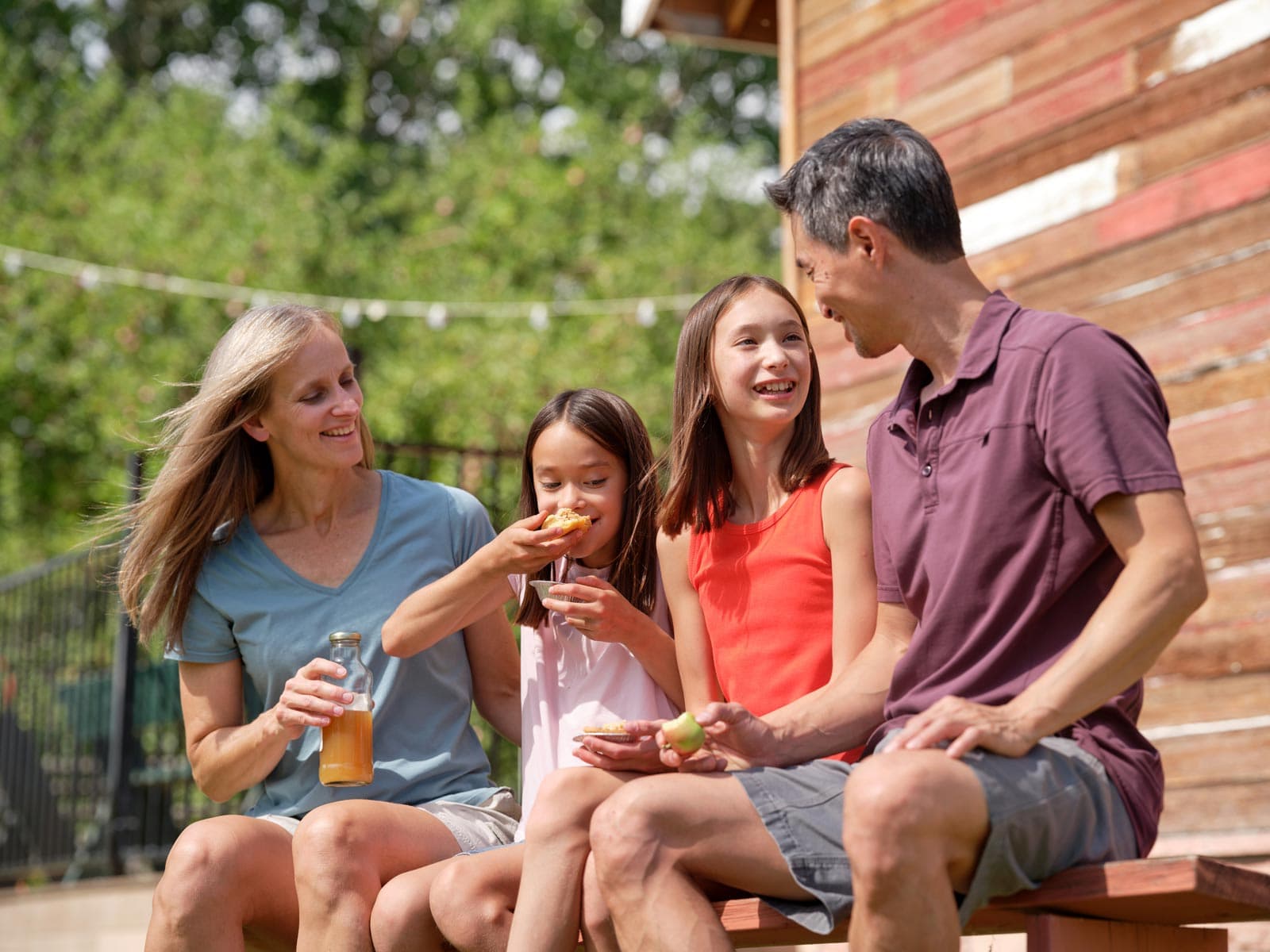 A family drinks apple juice on a picnic table