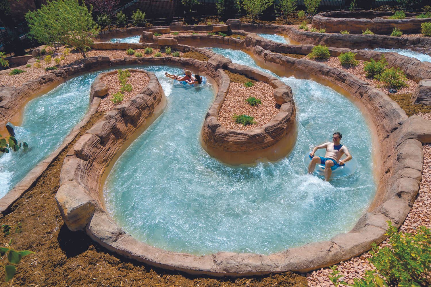 People float along a serpentine and fast-moving water chute at Glenwood Hot Springs Resort. They ride single and double clear inflatable tubes. Shoshone Chutes at Glenwood Hot Springs Resort