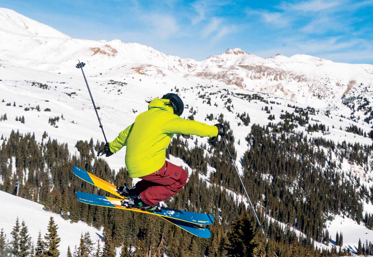 Someone in colorful winter gear flies through the air on skis in Loveland.