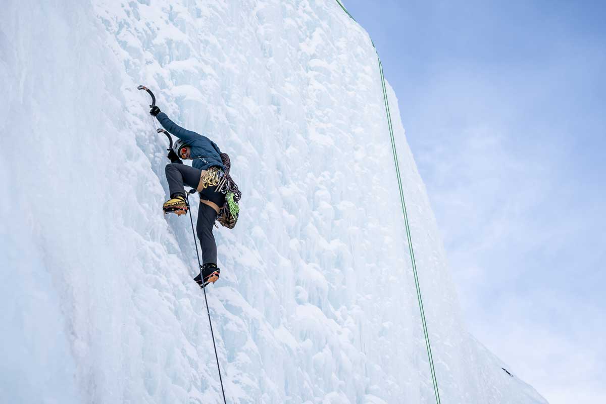 An ice climber using ice picks nears the top of an ice wall in Lake City, Colorado.