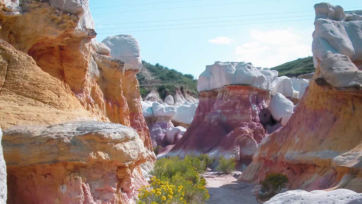 A trail through rocks with layers of red and orange colors