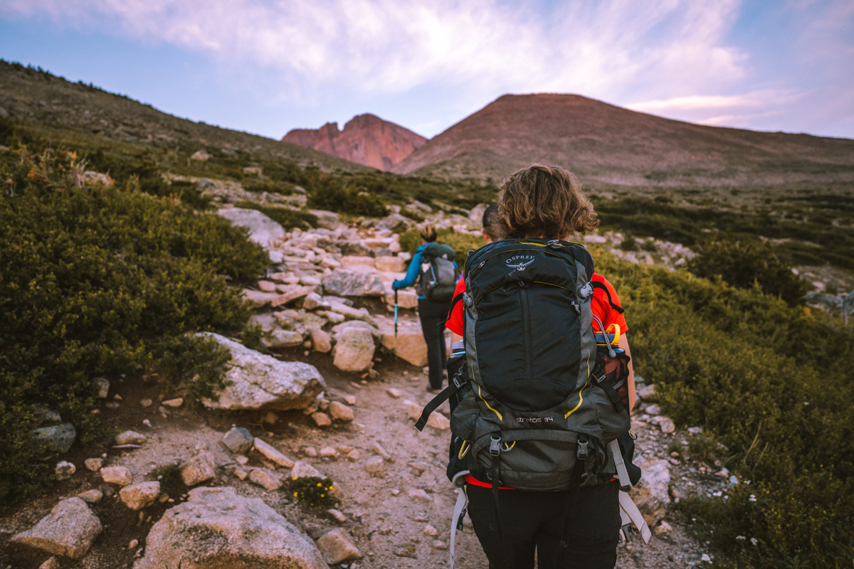 People hike up a rocky trail to a mountain summit in Estes Park, Colorado.