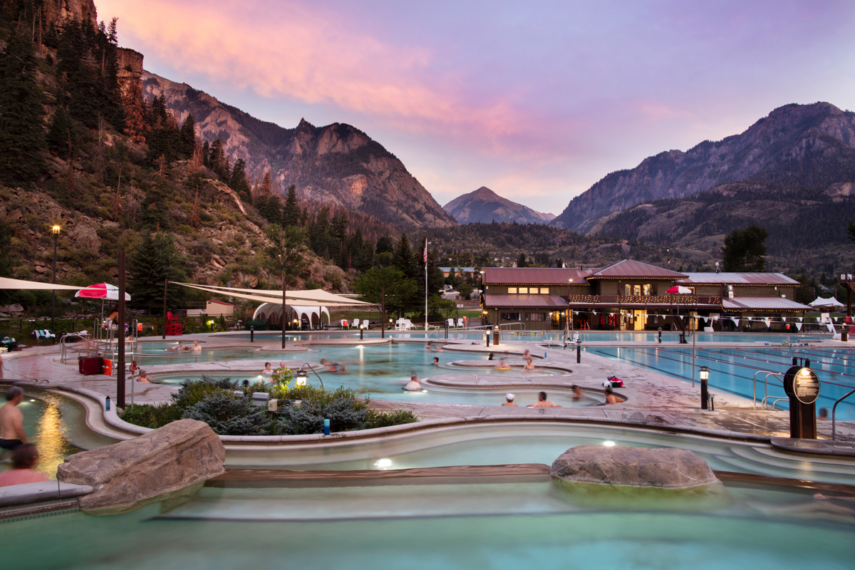 People soaking in pools and admiring the mountain views at Ouray Hot Springs Pool in Colorado