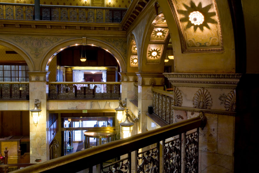 Ornate hotel lobby with stone and iron detailing, overlooking the lobby from an atrium