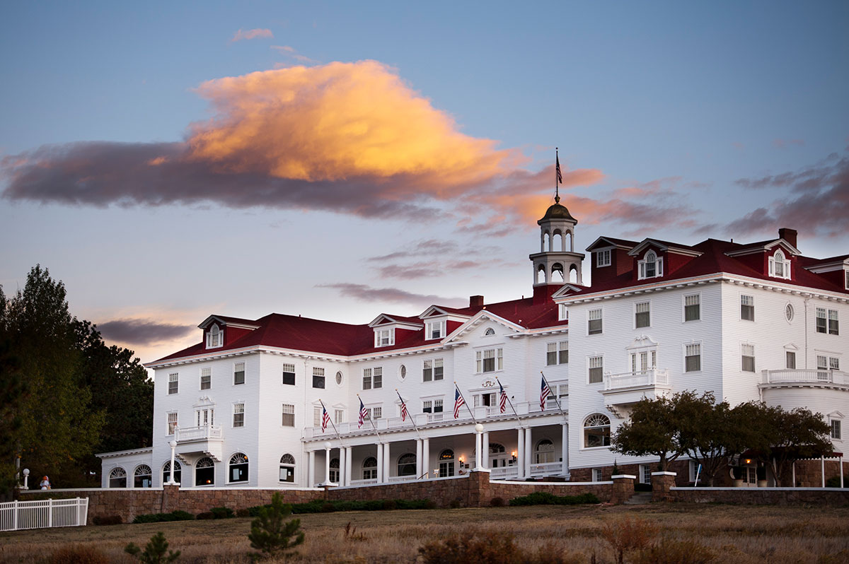 Exterior of a large white hotel building with a red roof
