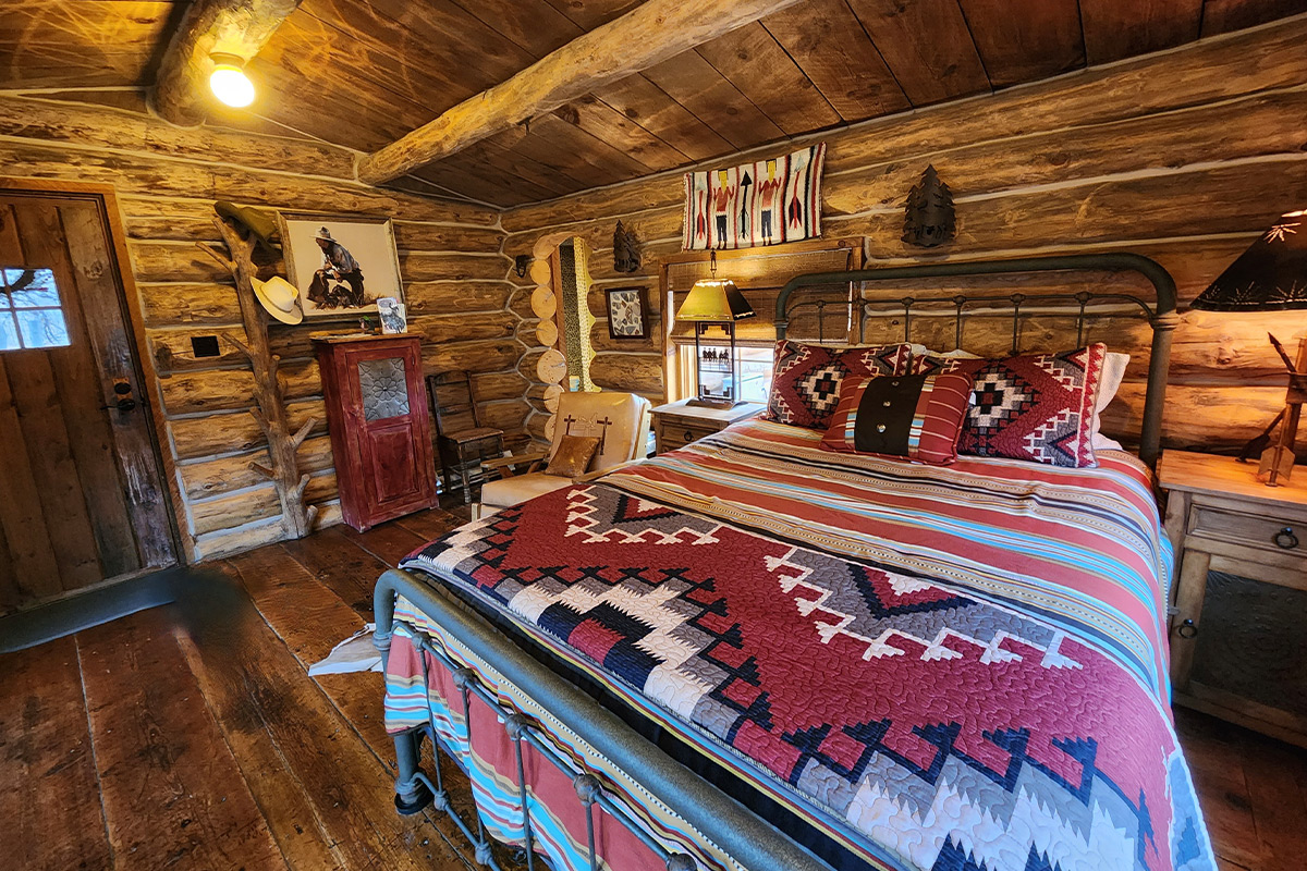 A guest room at the Canyon of the Ancients Guest Ranch features a blend of Southwestern patterns and cowboy-themed decorations.
