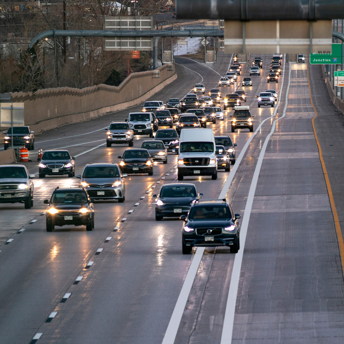Cars on the road and a black vehicle crossing solid lines, violating the express lane rules.