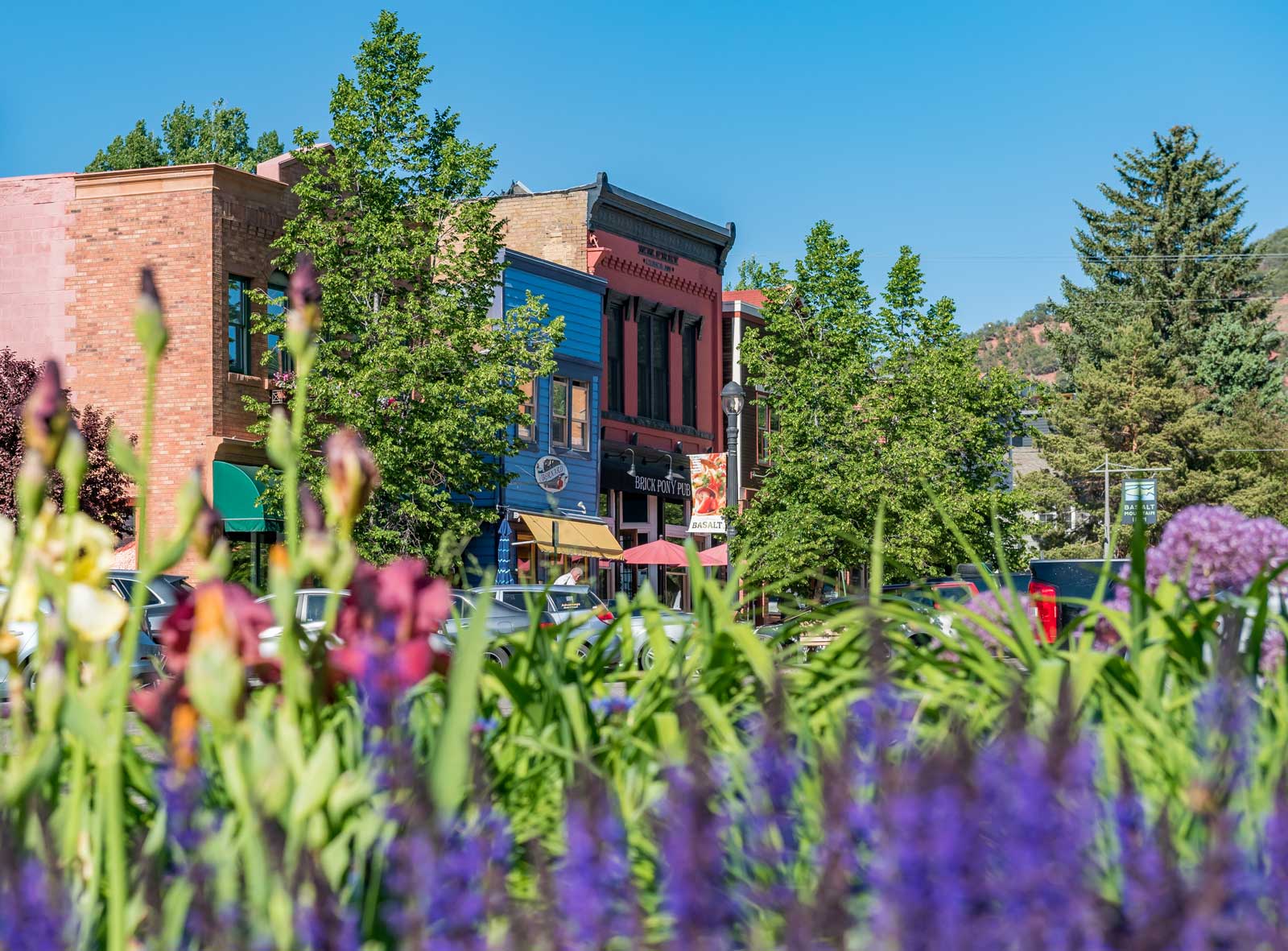 Flowers bloom in front of 1800s-era brick storefronts in Basalt, Colorado