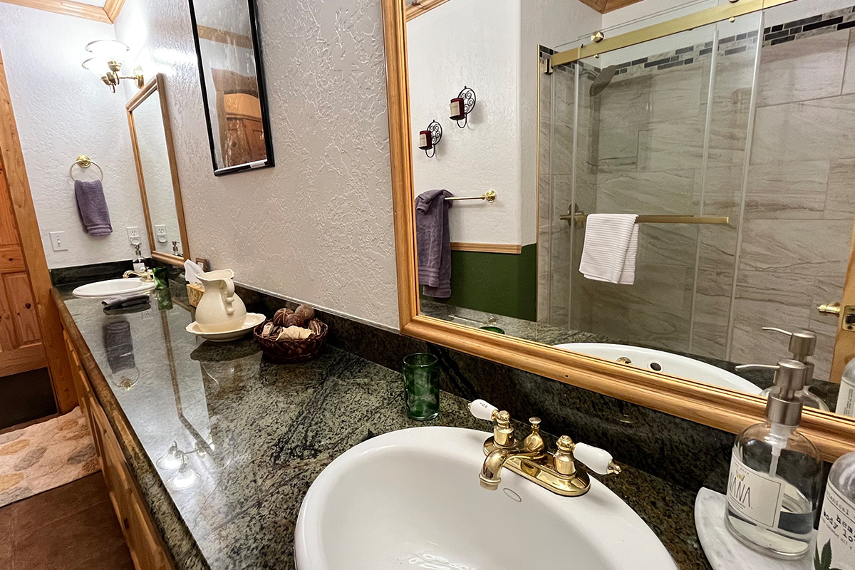 At Elkwood Manor Bed & Breakfast in Colorado, a private guest room en suite features a double sink and a stone-lined shower.