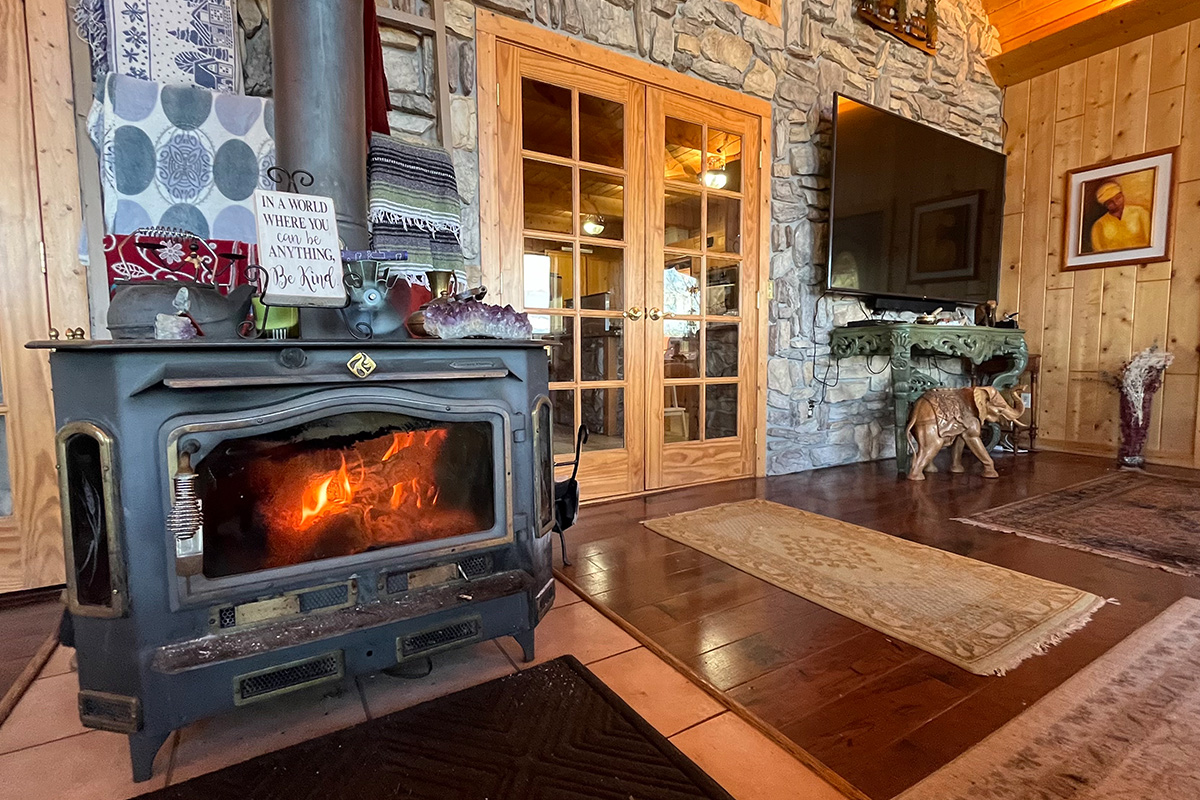 A stove fireplace contains a crackling, cozy fire at the Elkwood Manor Bed & Breakfast in Colorado.