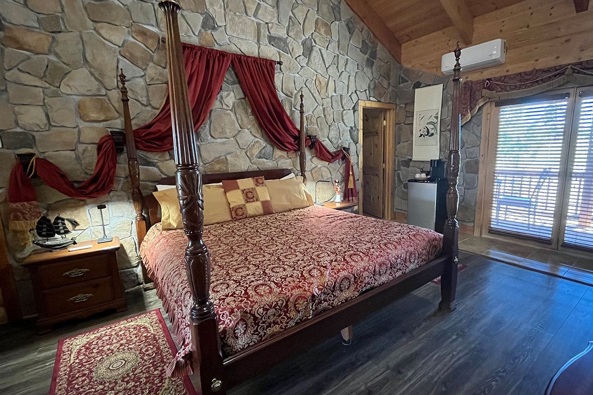 A guest room at the Elkwood Manor Bed & Breakfast in Colorado features romantic decor and a private balcony space.