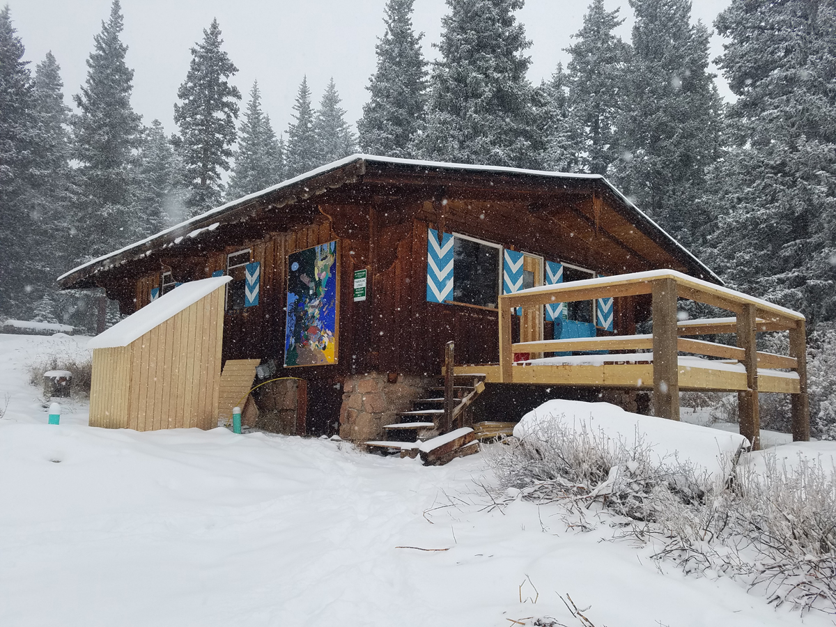 One of the nine backcountry huts Colorado Adventure Guides has access to, surrounded by snow-flocked evergreens and blankets of fresh powder.