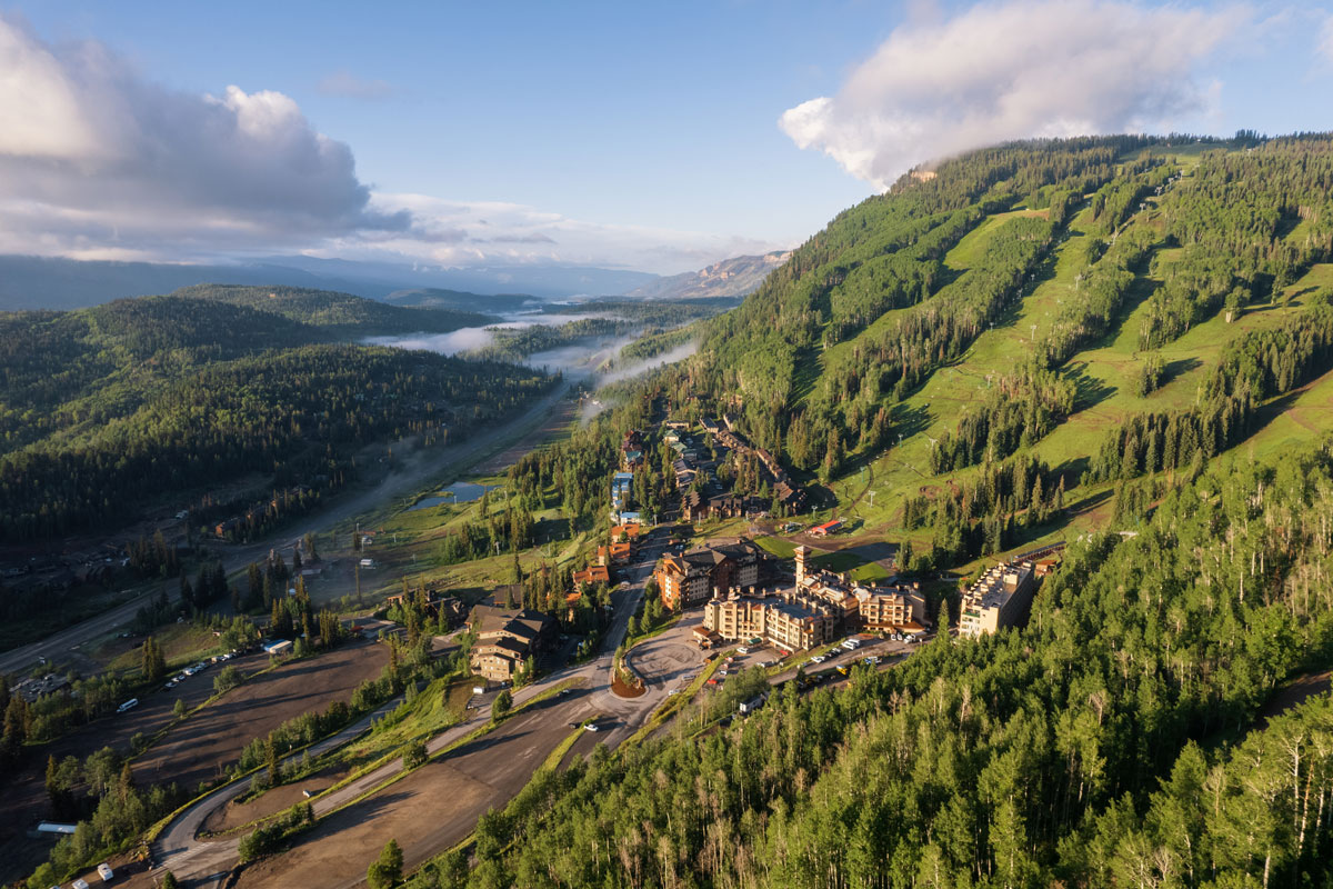Aerial view of Purgatory Resort nestled in a lush valley, surrounded by forests in Durango.