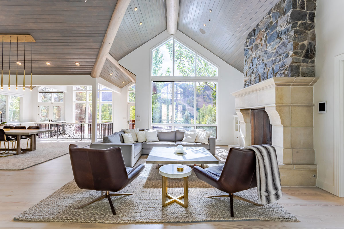 A spacious and airy living room of modern and wood designs with a large floor-to-ceiling window in Aspen, Colorado.