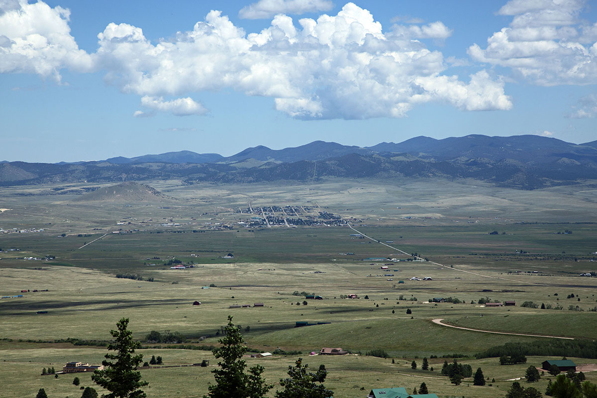 Daylight far away views of a green valley with mountains far away standing tall.