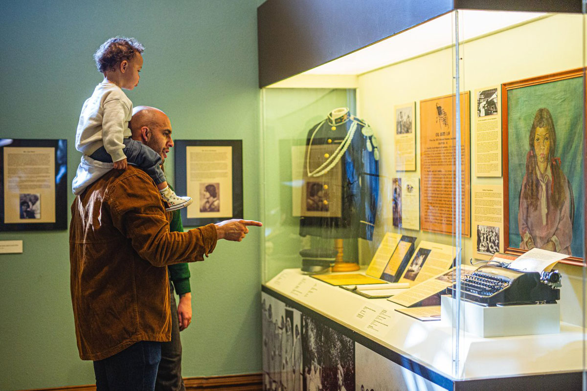 A father and son look at a historical display at the Colorado Springs Pioneers Museum