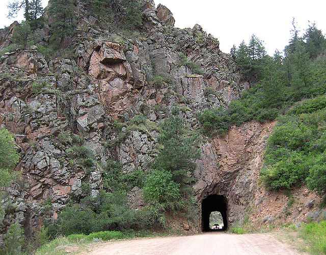 A car tunnel is bored through a mountain peak