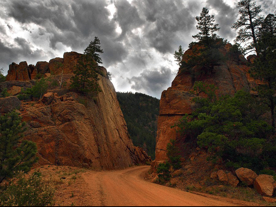 Dark clouds roll over two red-rock formations