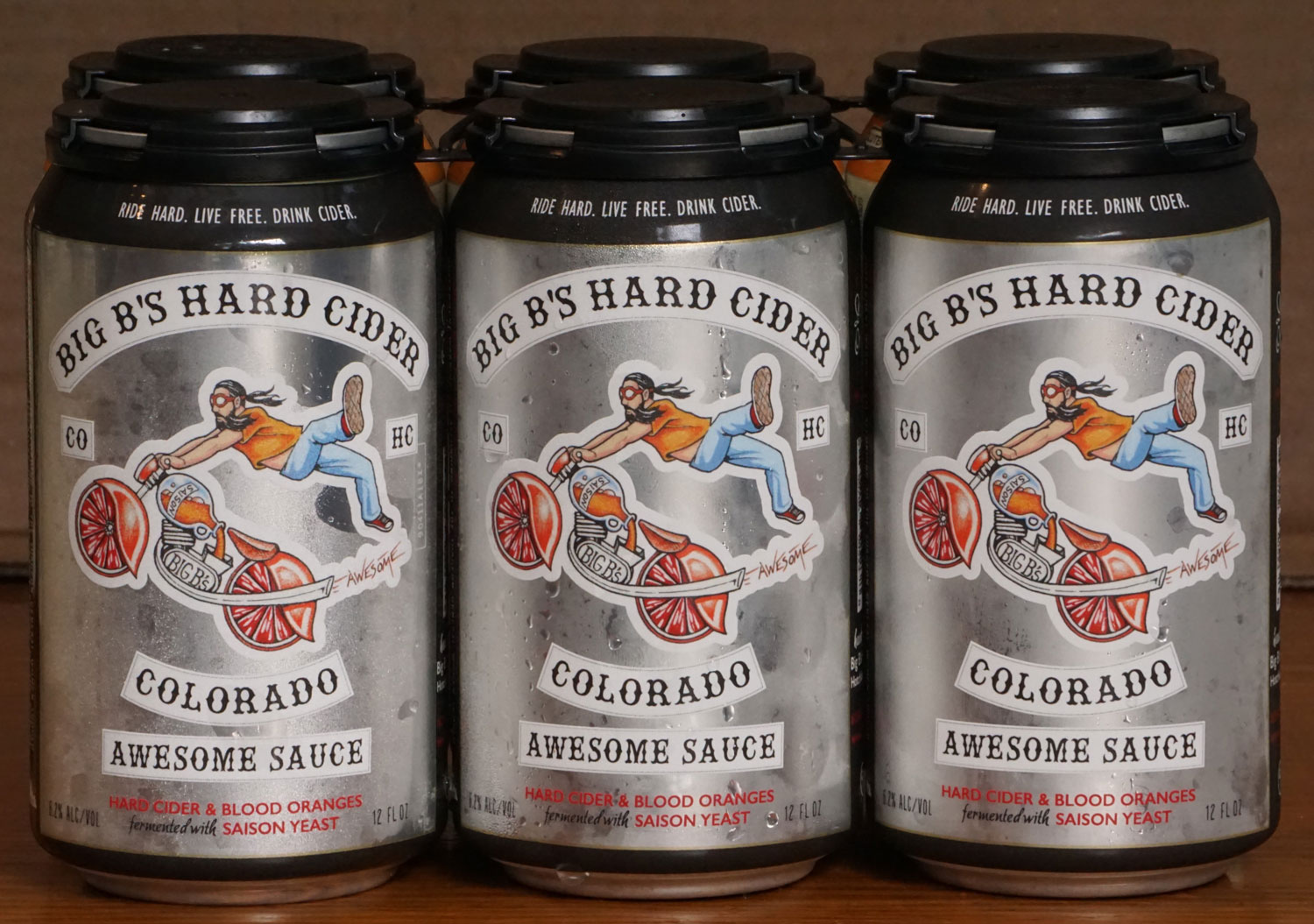 A design on a can of Big B's Hard Cider, Hotchkiss, features a person flying off a cider and fruit-style motorcycle.
