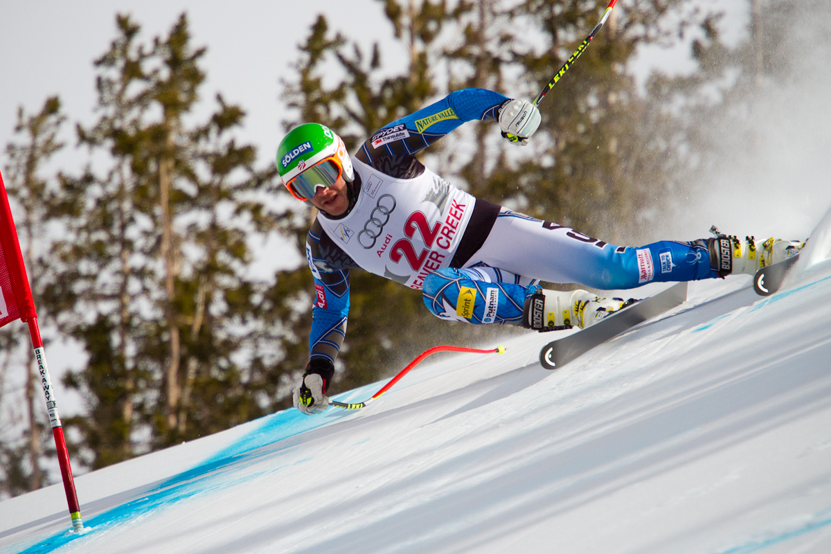 An athlete wearing a bid marked with the number twenty-two, competes in a ski competition by racing down a snowy slope and around red flags in Colorado.