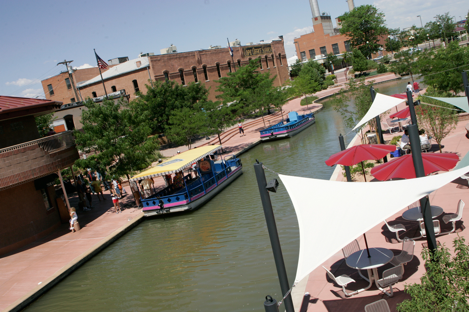 Boats float on the water on a sunny day at Pueblo's Historic Arkansas Riverwalk
