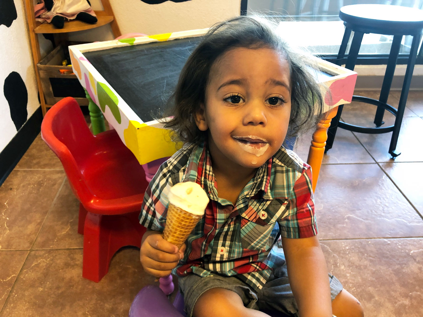 A child dug into their vanilla ice-cream cone with relish and now has a ring of food around their mouth at the Caffeinated Cow in Colorado.