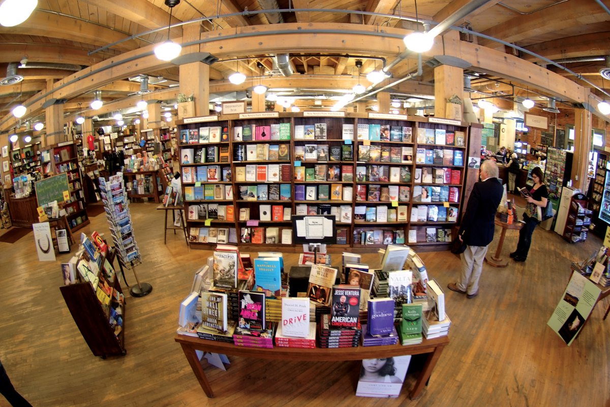 People browse shelves of books inside a quaint bookstore