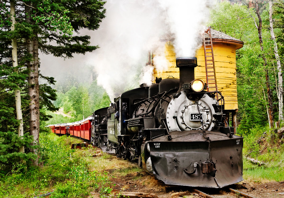 A train steams through a mountain track