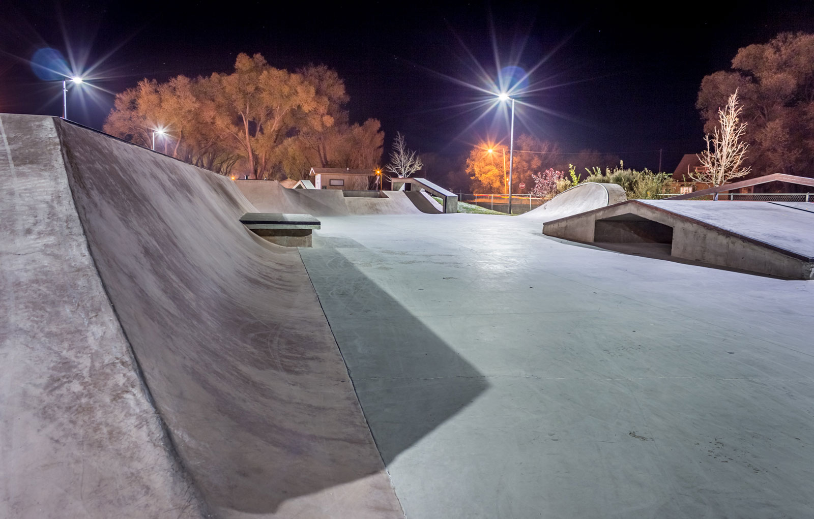 The Monte Vista Skate Park at night with trees in the background.