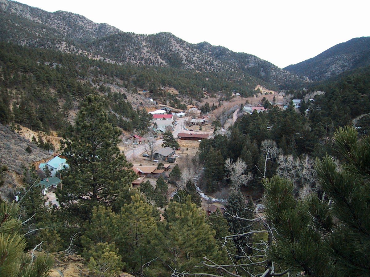 An aerial view of Jamestown, which is nestled in a valley surrounded by evergreen trees and mountain peaks.