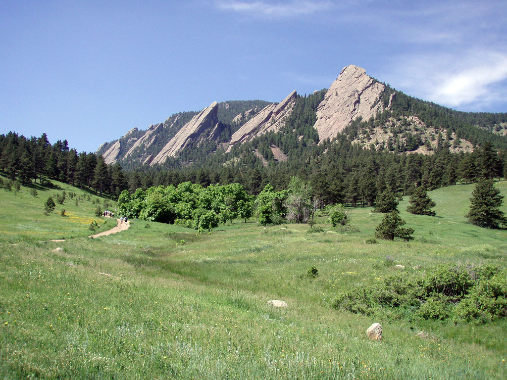 Massive, slanted rock slabs jutting out of the earth form the iconic Flatirons near Boulder, Colorado.