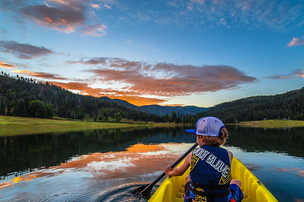 A child paddling on a yellow kayak on Lemon Reservoir