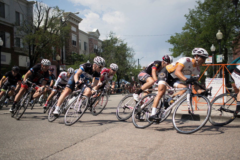 A group of cyclists turn during the Twilight Criterium through downtown Littleton.